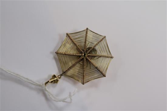 An early 20th century yellow metal spiders web pendant with gem set spider and diamond set bale, 30mm.